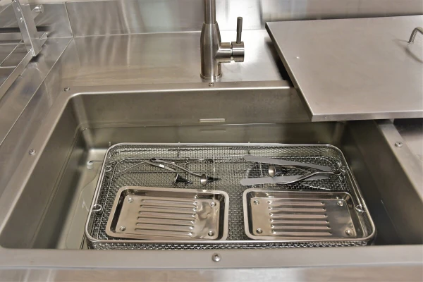 Использованный инструмент попадает в красную зону, где сначала дезинфицируется в специальном растворе в ультразвуковой мойке - TOP Clinic DENIS