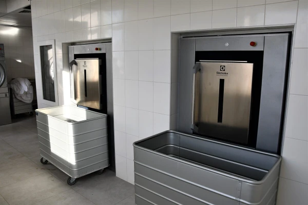 В прачечной установлены стиральные машины барьерного типа. Это означает, что загрузка грязного белья проводится в одном помещении, а выгрузка чистого — в другом. - TOP Clinic DENIS